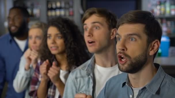 Sad sport fans tittar på match i bar, unga åskådare ser besviken — Stockvideo