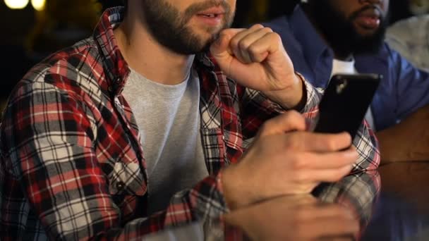 Férfi pub aggódni nyerő sport lottó, ellenőrzése fogadások okostelefonon — Stock videók