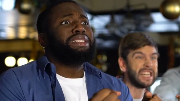 Homens multiétnicos torcendo pelo jogo vencedor da equipe esportiva, celebrando o gol no pub — Vídeo de Stock