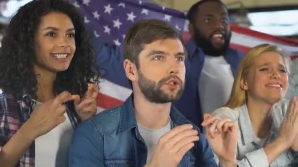 Abanicos en bar con bandera americana celebrando la victoria de la selección nacional de fútbol — Vídeo de stock