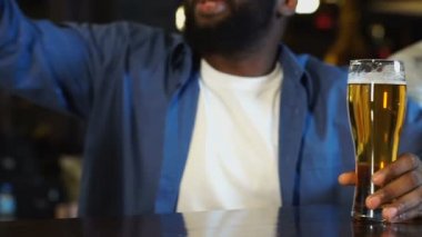 Afrikalı Amerikalı adam pub oturan beyaz arkadaşı oyun stratejisi açıklayan