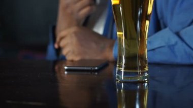 Afrika Amerikan adam spor pub oturma bira içme ve arama bekliyor