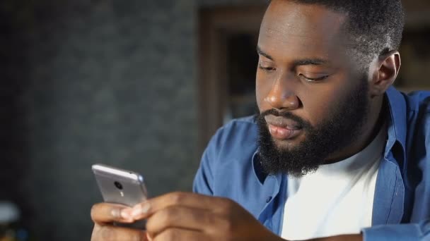 Hombre afroamericano guapo leyendo perfiles en citas sitio web, servicio en línea — Vídeos de Stock