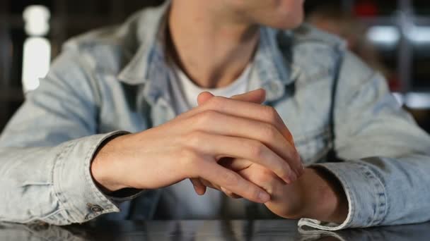 Nervöser junger Mann sitzt in gemütlichem Café, schaut sich um und wartet auf Mädchen, Date — Stockvideo