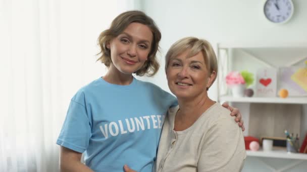 Vrouwelijke vrijwilliger knuffelen Senior Lady, gepensioneerden Assistance Program, ondersteuning — Stockvideo