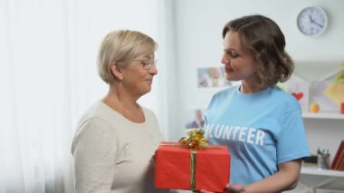 Mutlu kadın gönüllü t-shirt veren hediye kutusu için yaşlı Bayan, tatil Charity