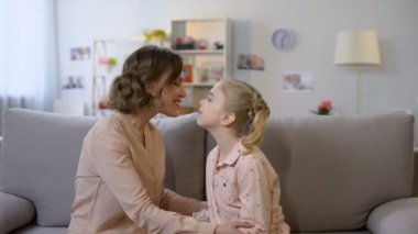 Genç Anne ve kızı kanepede oturan nuzzling, yakın aile ilişkileri, aşk