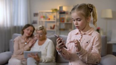 Akıllı telefon uygulaması, Büyükanne ve anne kaydırma tablet kullanarak gülümseyen çocuk
