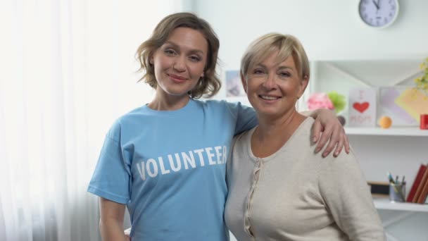 Mulher madura e jovem apontando para inscrição voluntária na camiseta — Vídeo de Stock