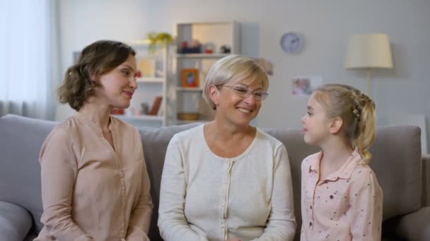 Junge Frau und Kind küssen Großmutter Wangen, umarmen sich, Familienliebe — Stockvideo