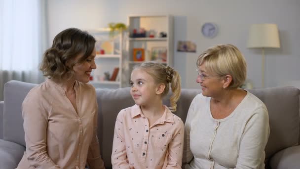 Loving mother and granny kissing daughter cheeks and hugging, female generations — Stock Video