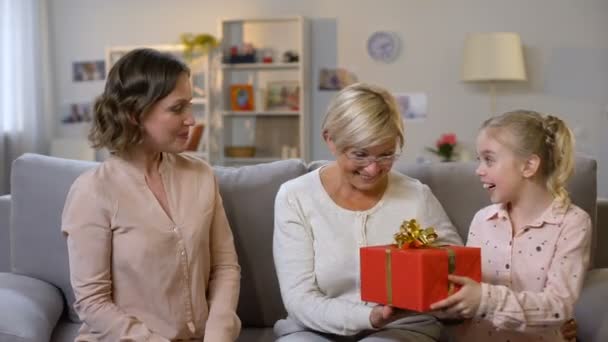 孫娘がいるお年寄りの女性がプレゼントボックスの母 休日の伝統を提示 — ストック動画