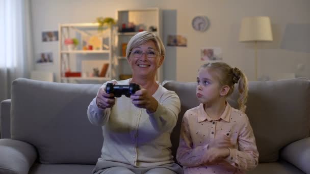 心烦意乱的孙女从奶奶手中拿着游戏操纵杆 误会了 — 图库视频影像