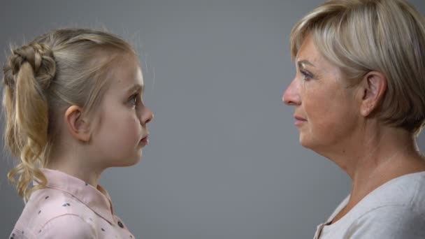 Señora mayor mirando a la niña, reflexión presente pasado, recuerdos de la infancia — Vídeo de stock