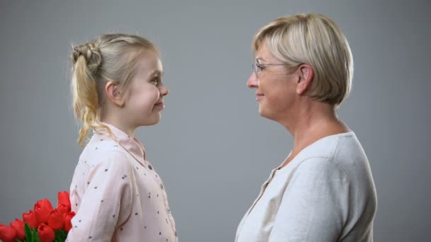 Schöne Seniorin nimmt Blumen Geschenk von Enkelin und Umarmung, Liebe — Stockvideo