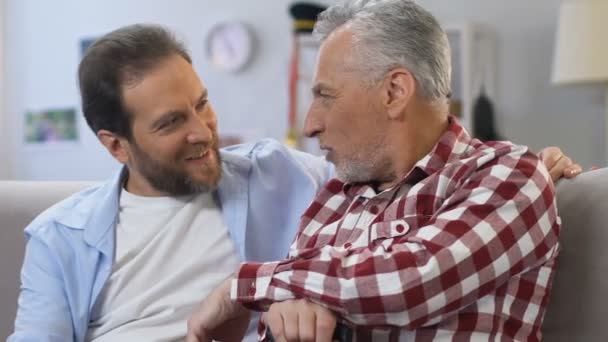 Friendly father and son chatting sitting in living room, cozy family atmosphere — Stock Video