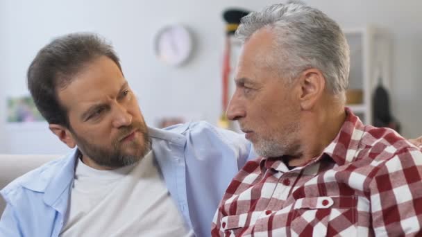 Padre dalla barba grigia che racconta storie dalla vita al figlio di mezza età, relazioni — Video Stock