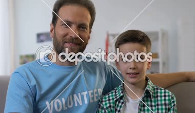 Adam ve erkek kamera için poz, yetim, evlatlık küçük çocuk ziyaret gönüllü