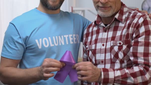 Dos hombres sosteniendo cinta violeta, voluntarios apoyando al anciano, enfermedad de Alzheimers — Vídeos de Stock