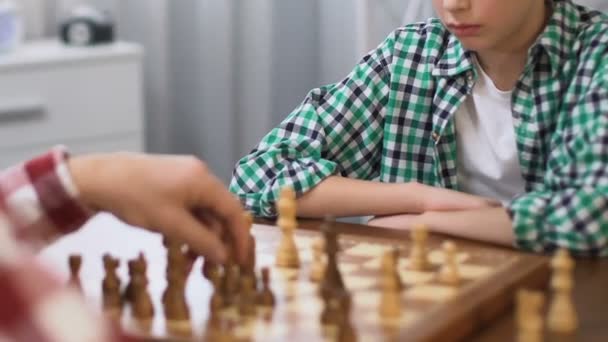 Father teaching son to play chess, development of logical thinking, family hobby — Stock Video