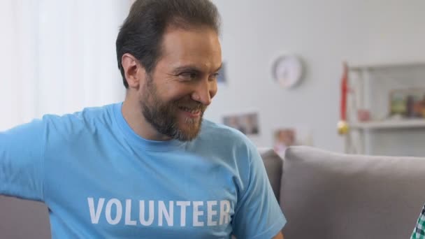 Mannelijke vrijwilliger realiseren droom van kleine jongen wees, presenteren bokshandschoenen — Stockvideo