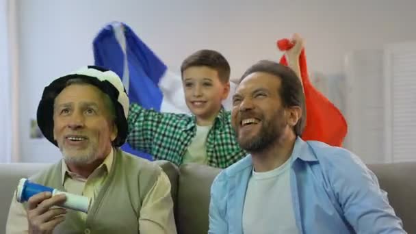 Famille regardant match de football à la maison, garçon avec le drapeau français acclamant pour la victoire — Video