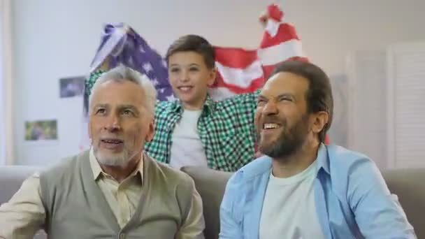 Ragazzo sventola bandiera americana, famiglia guardando partita nazionale di calcio a casa — Video Stock