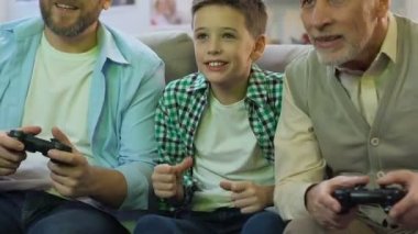 Baba ve Büyükbaba evde video oyunu oynarken, zafer için tezahürat çocuk, dinlenmek