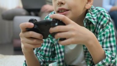 Çocuk evde video oyunu oynarken, aile arka planda Gadget 'ları kullanarak, bağımlılık