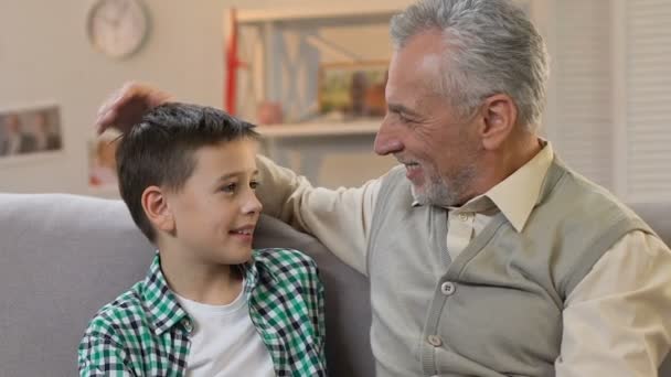 Abuelo acariciando la cabeza del nieto, abrazando y mirando a la cámara, tiempo en familia — Vídeos de Stock