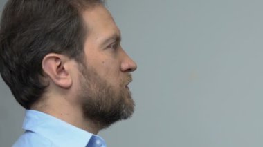 Gri arka planda ciddi orta yaşlı adam ayakta, iş arama istatistik