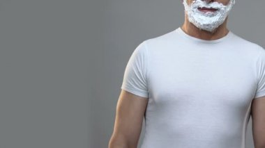 Elleri ile ayakta emin adam dikili ve yüz üzerinde tıraş köpük, hijyen
