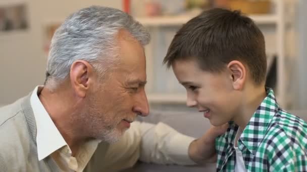 Uomo anziano che tocca la fronte con nipote, amore familiare e gesto di cura — Video Stock