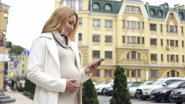 Улыбающаяся Беременная Женщина Читает Телефонные Сообщения Приложение Родов Мечтает — стоковое фото