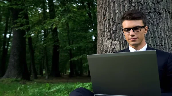 Homem Negócios Sério Trabalhando Laptop Sentado Debaixo Árvore Parque Central — Fotografia de Stock