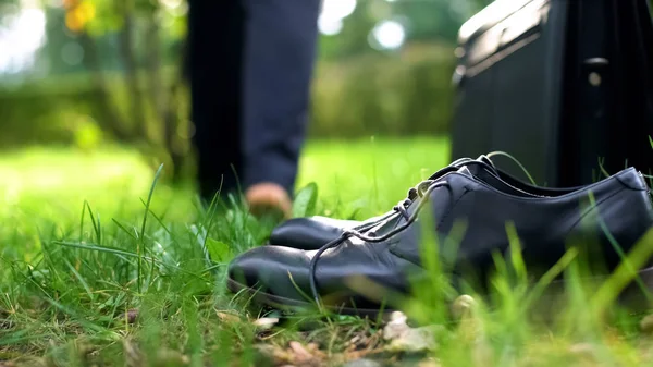 緑の草 前景上のブリーフケースで裸足で歩くサラリーマン — ストック写真