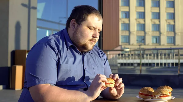 Overvektig Mann Som Ser Hamburger Nøler Med Spise Velger Sunn – stockfoto