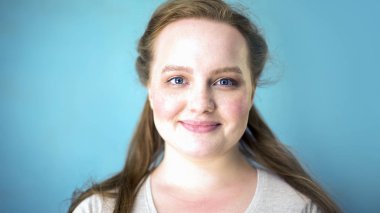 Kameraya, mavi arka planı arıyorum çiller ile tombul kadın portresi