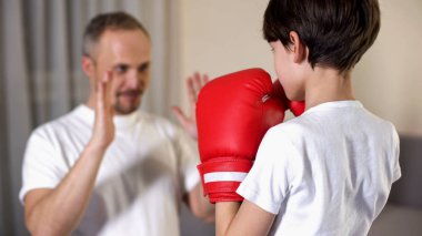 Little boy boxing with his step-father, learning attacking, family togetherness clipart