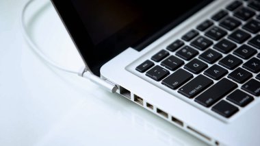 Laptop güç adaptörü takılı, şarj, ofis çalışması teknoloji gadget