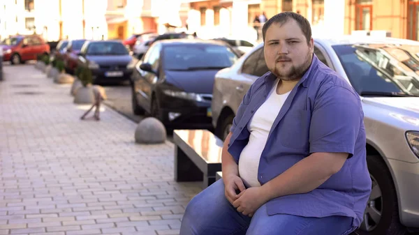 Sad fat bachelor sitting on bench alone, feeling lonely, having no friends