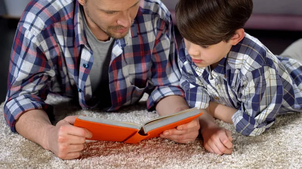 专心爸爸和儿子读有趣的百科全书为男孩 — 图库照片