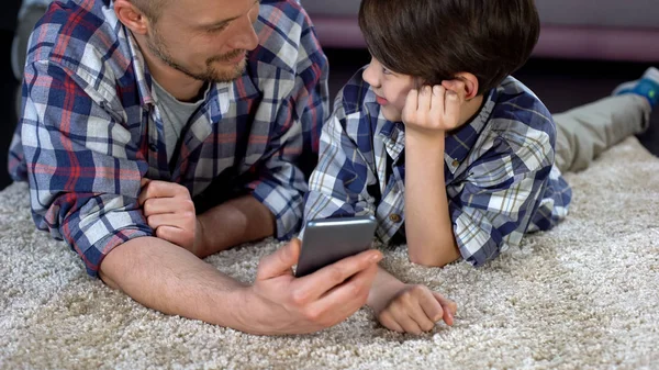 아들과 아버지는 바닥에 스마트폰 게임에서 엄마를 기다리는 — 스톡 사진