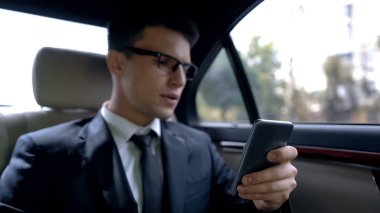Mutsuz yakışıklı işadamı smartphone, kötü haberleri okuma binmek lüks otomatik olarak