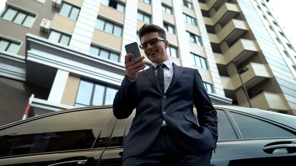 Başlangıç için finansman alınan smartphone cep telefonu ile iyi haber okuma takım elbiseli genç erkek