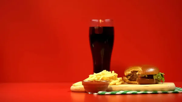 Frisdrank Met Gebeten Hamburger Frietjes Rode Achtergrond Als Waarschuwing — Stockfoto