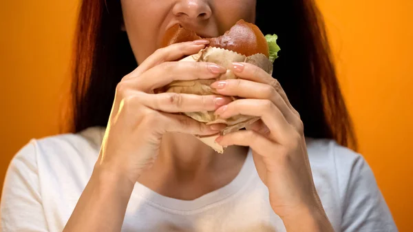 女人急切地吃着美味的芝士汉堡 不良的饮食习惯 不健康的零食 — 图库照片