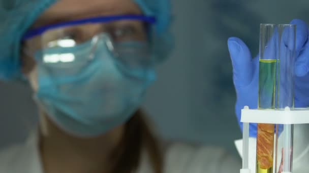 Expert de laboratoire examinant un échantillon de viande dans une éprouvette, surveillant le risque de réaction de l'asf — Video