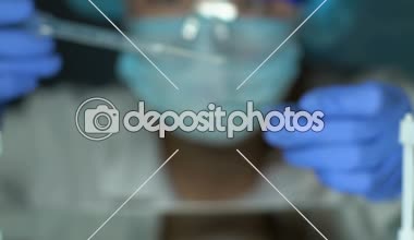 Laboratuvar bilim adamı cam üzerinde madde damlama, kozmetoloji uçucu yağlar