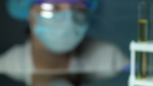 Laboratory worker checking yellow liquid test tube, essential oils in perfumery — Stock Video